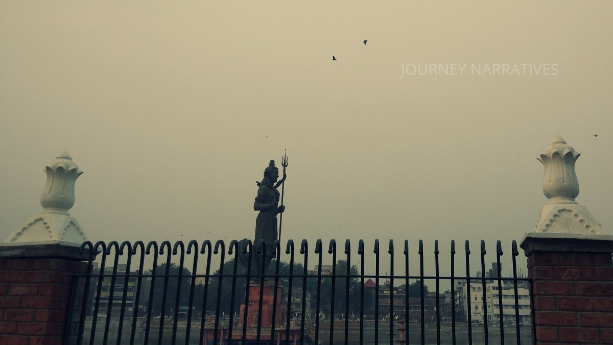 Scenic lake in Vadodara featuring a Shiva statue surrounded by urban landscapes