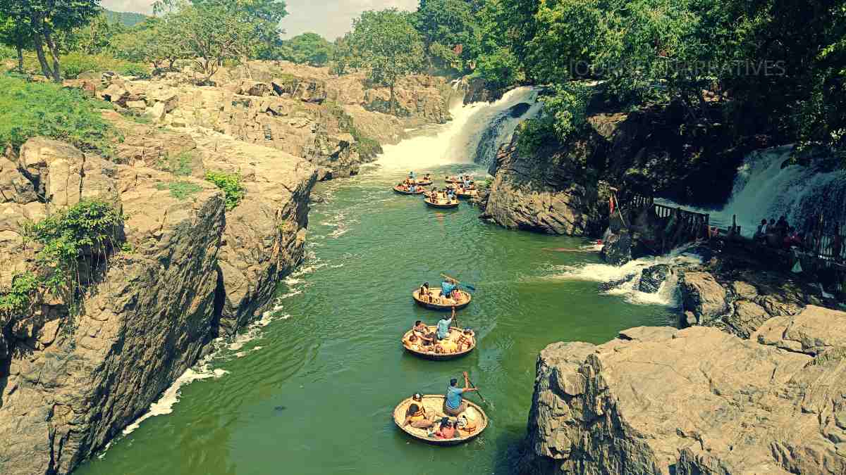 Traditional coracle ride on the Cauvery River at Hogenakkal Falls surrounded by rocky landscapes
