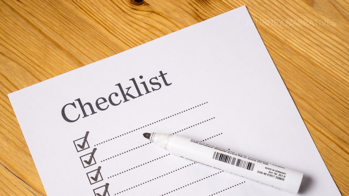 Travel essentials checklist written in a notebook to help travelers prepare for stress-free trips