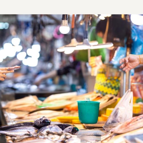Person exchanging cash in a local market, highlighting payment options available to travelers in India